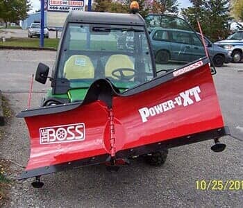 Green vehicle with red snow plow — Towing Services in Alma, MI Green vehicle with red snow plow — Towing Services in Alma, MI