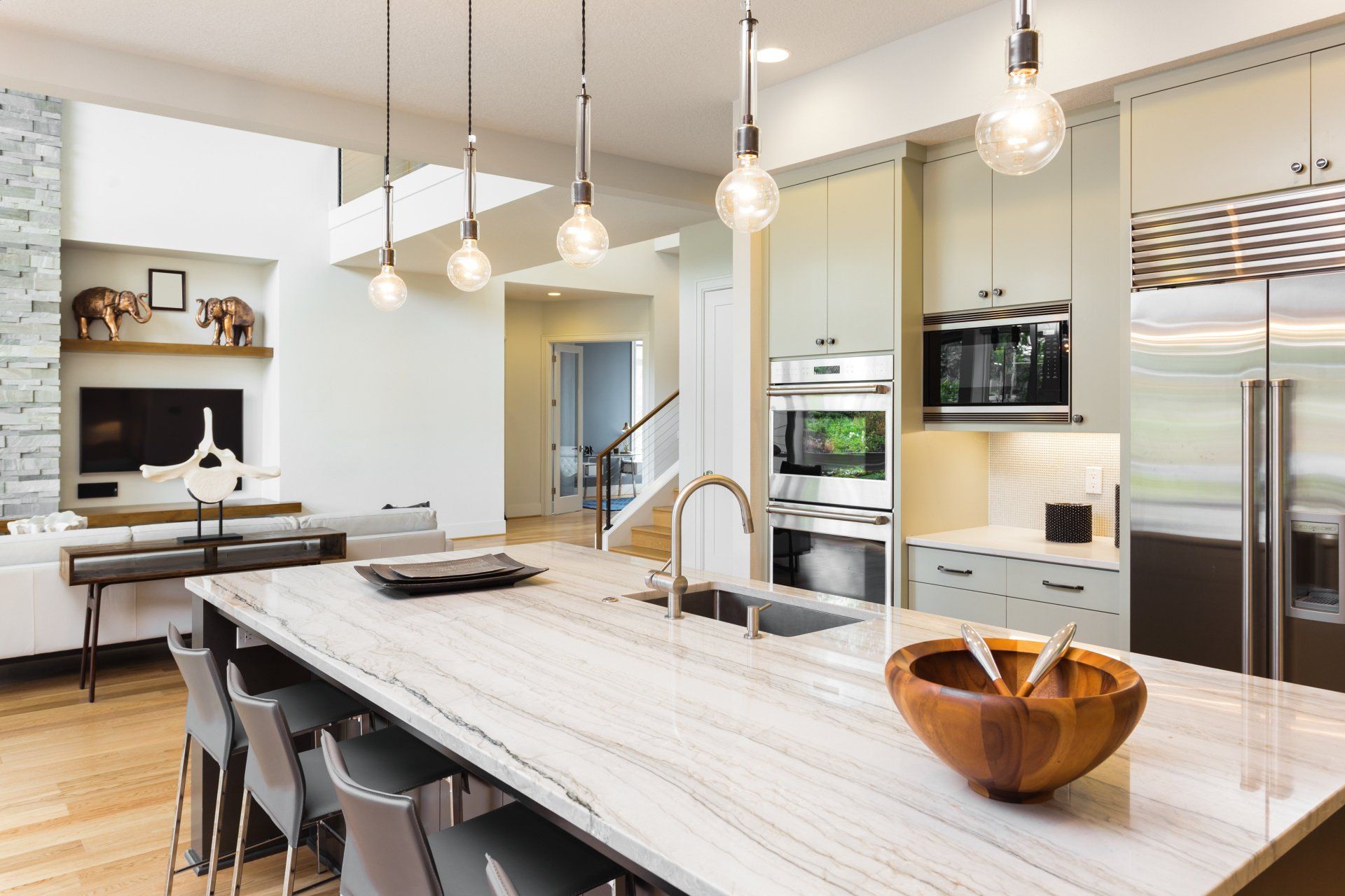 A kitchen with a large island and a wooden bowl on it.