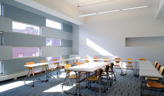 A classroom with a lot of tables and chairs