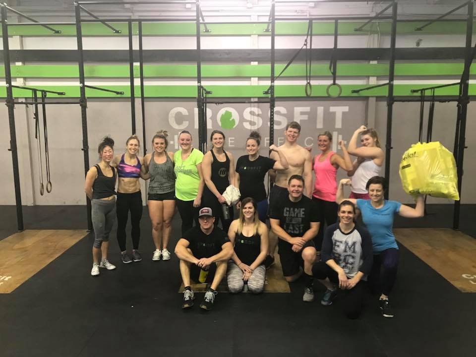 A group of people are posing for a picture in a gym.