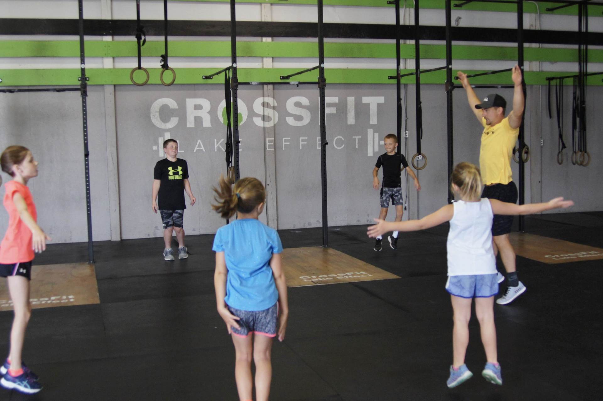A group of children are doing exercises in a gym.