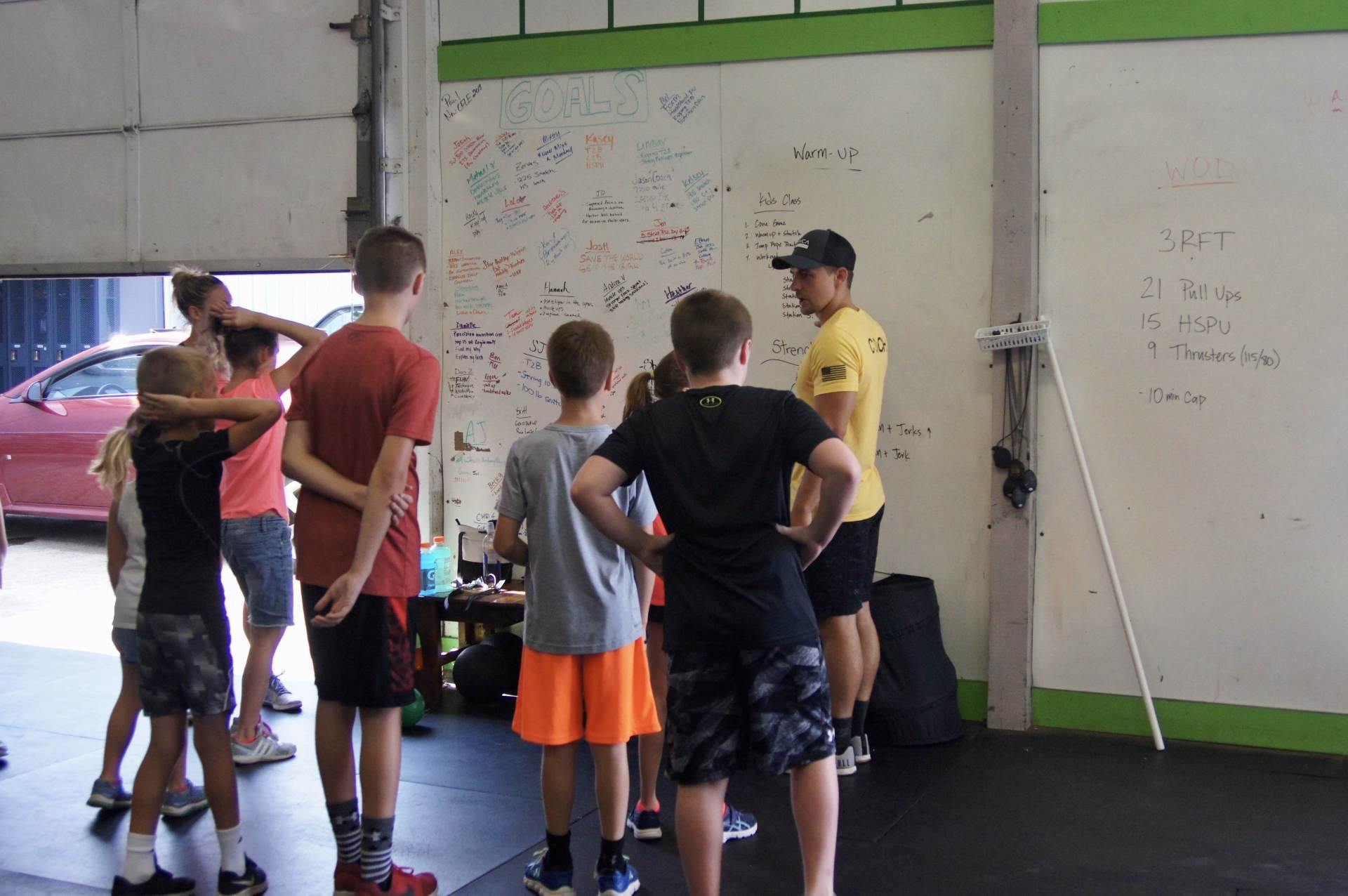 A group of young boys are standing in front of a white board