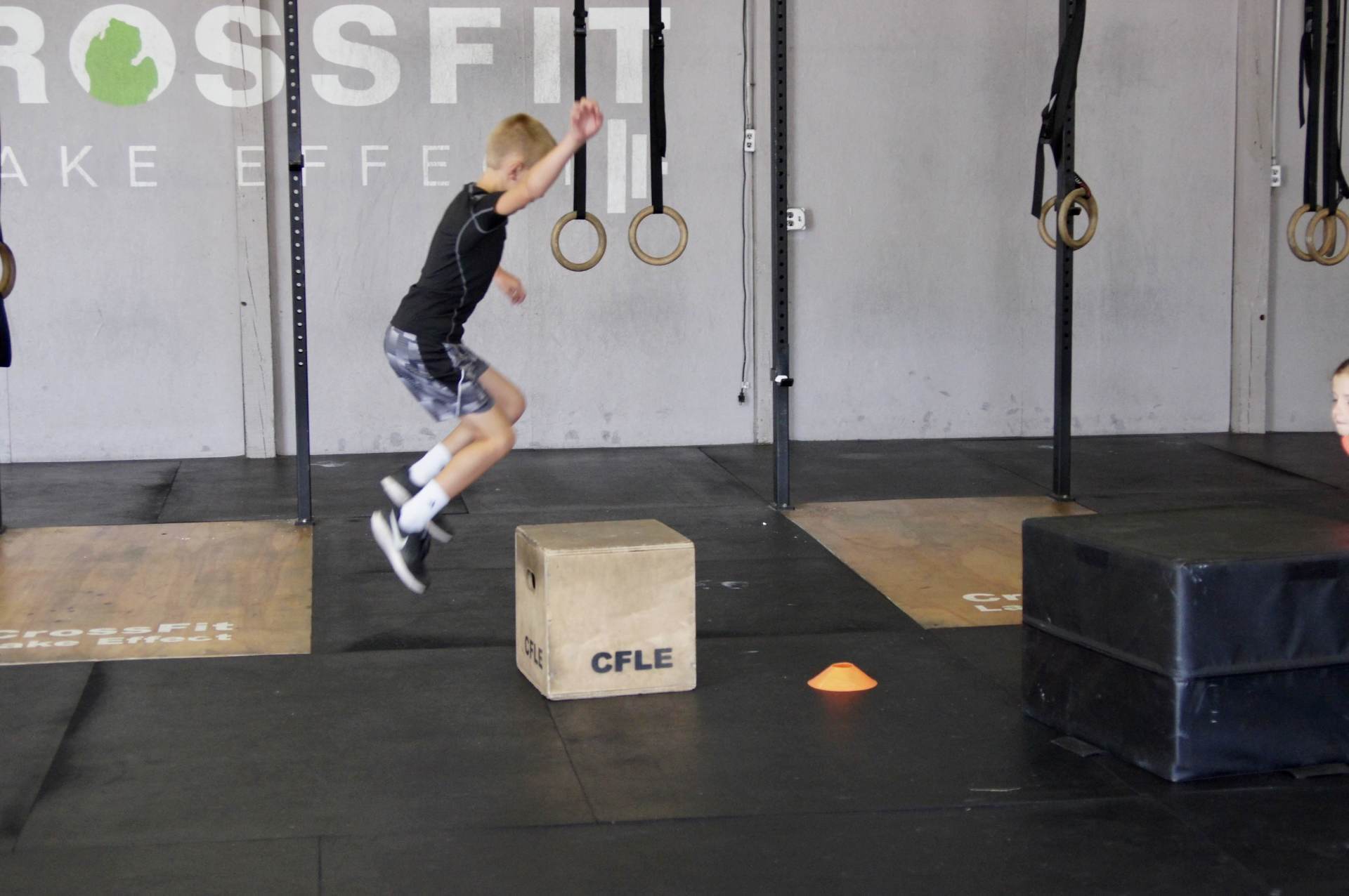 A boy jumps over a box that says cale on it