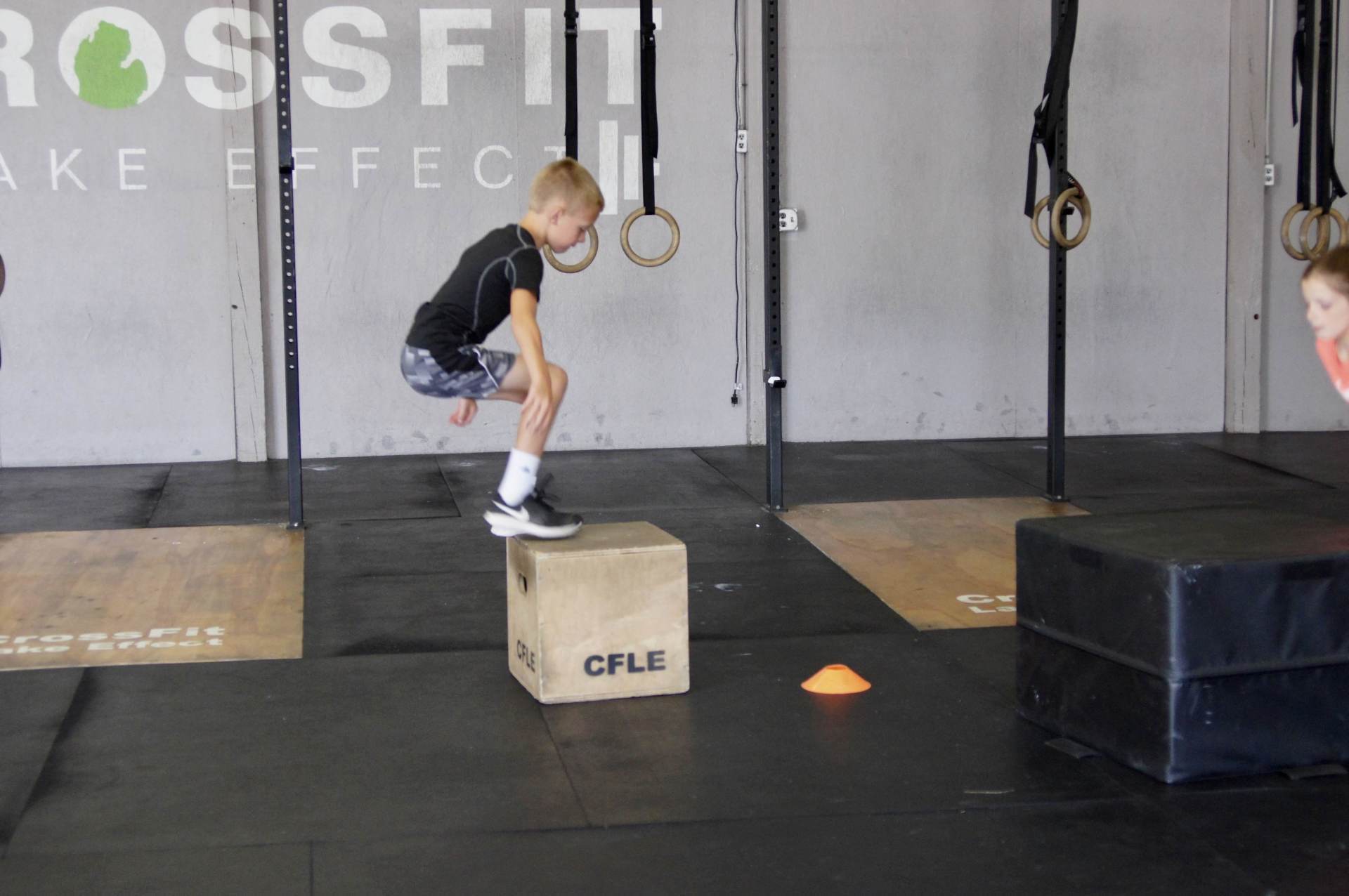 A boy is jumping on a box that says cfle on it