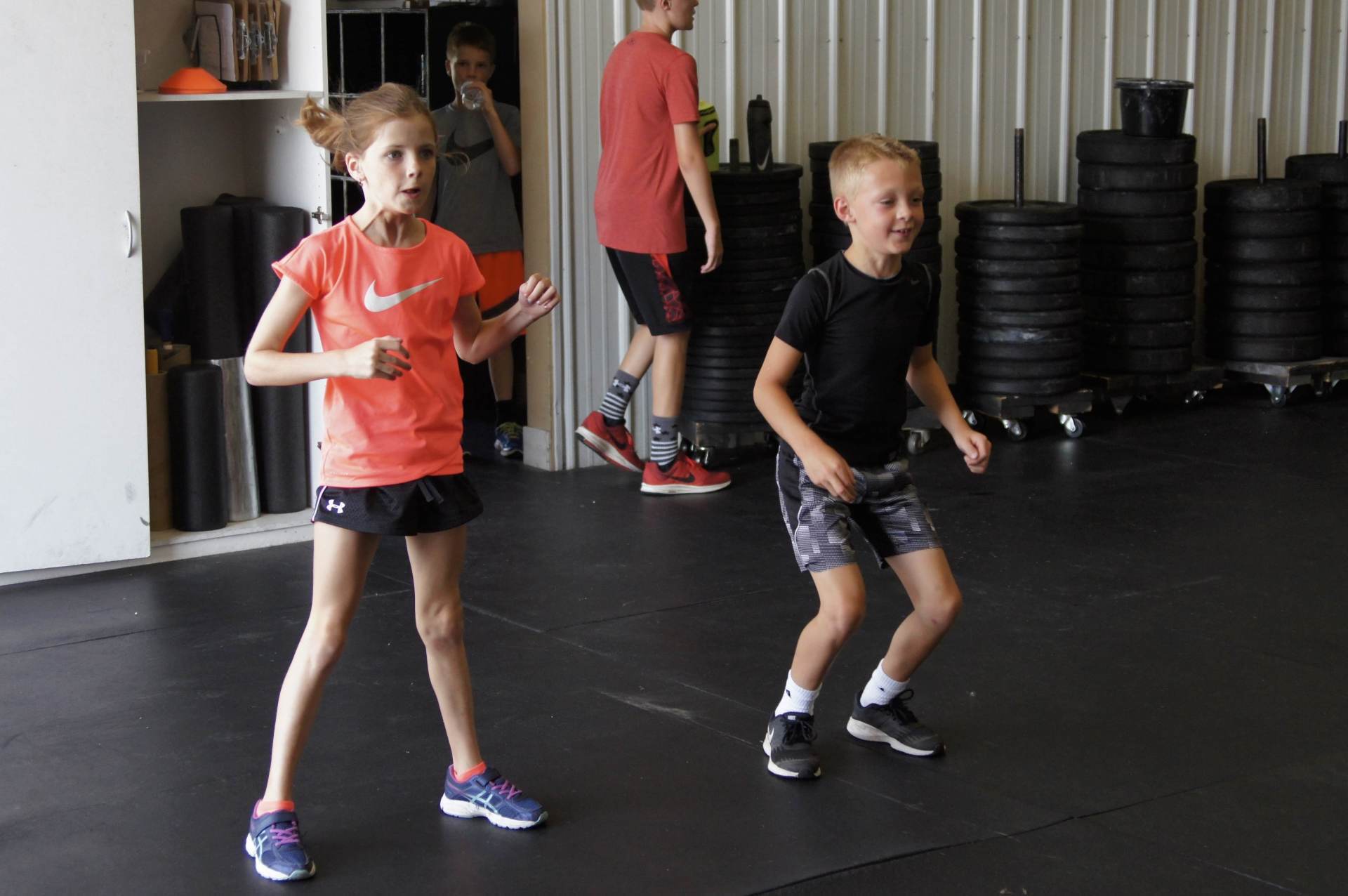 A boy and a girl are dancing in a gym.