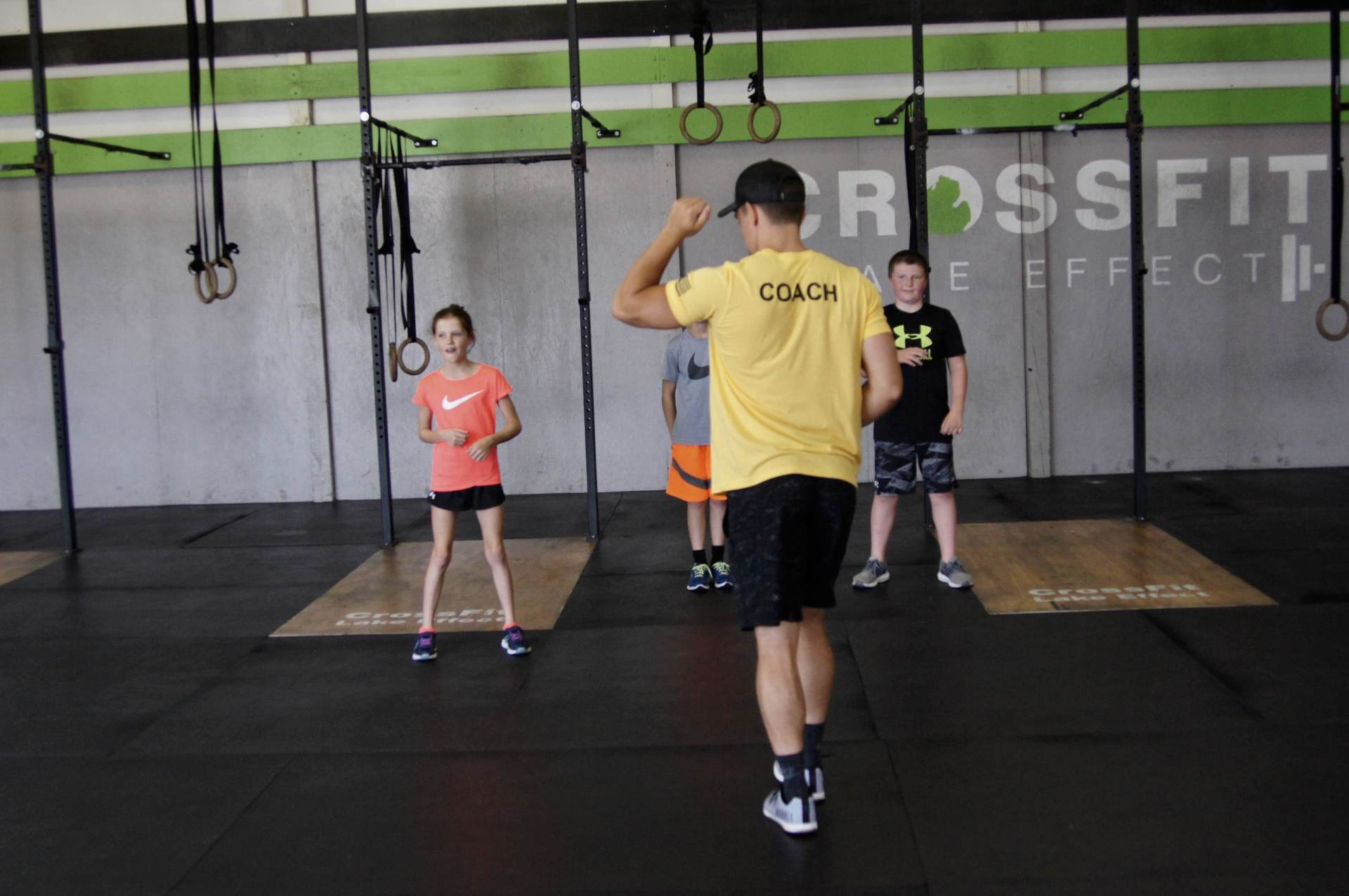 A man in a yellow shirt with the word coach on it
