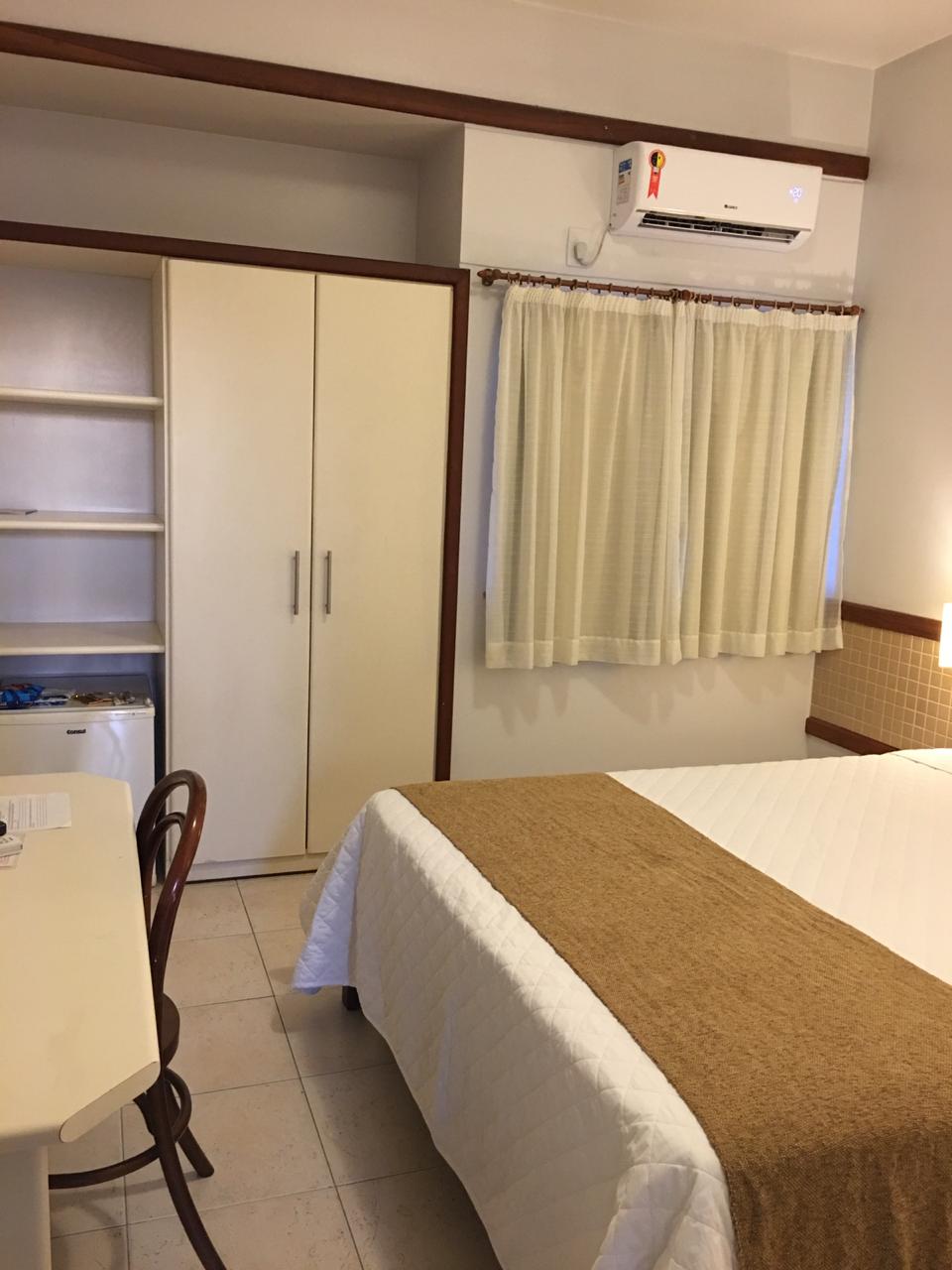 Um quarto de hotel com cama king size e mesa