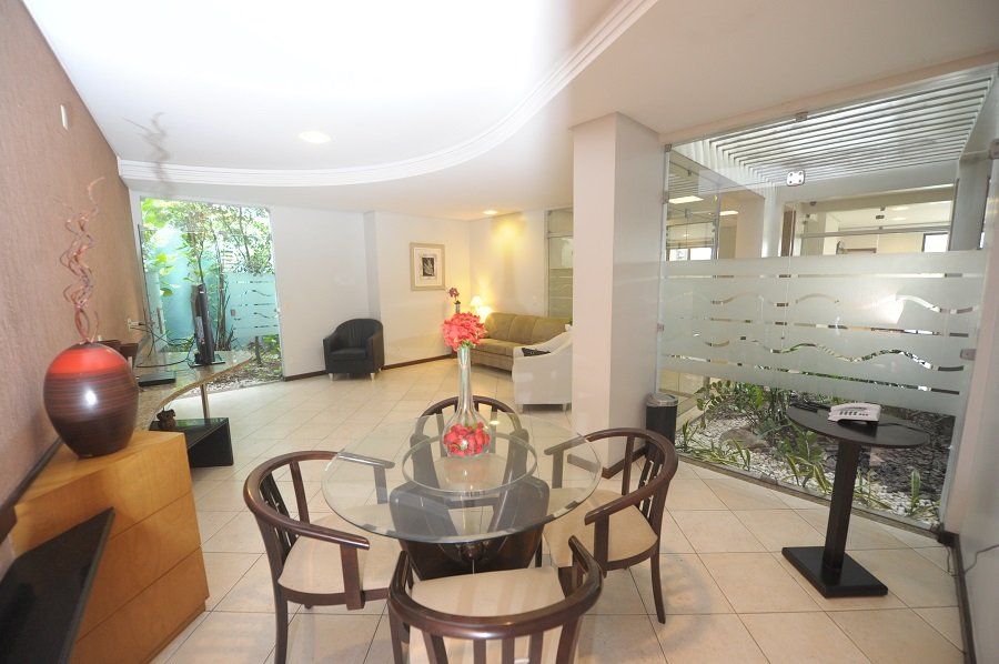 Uma sala de estar com mesa e cadeiras de vidro