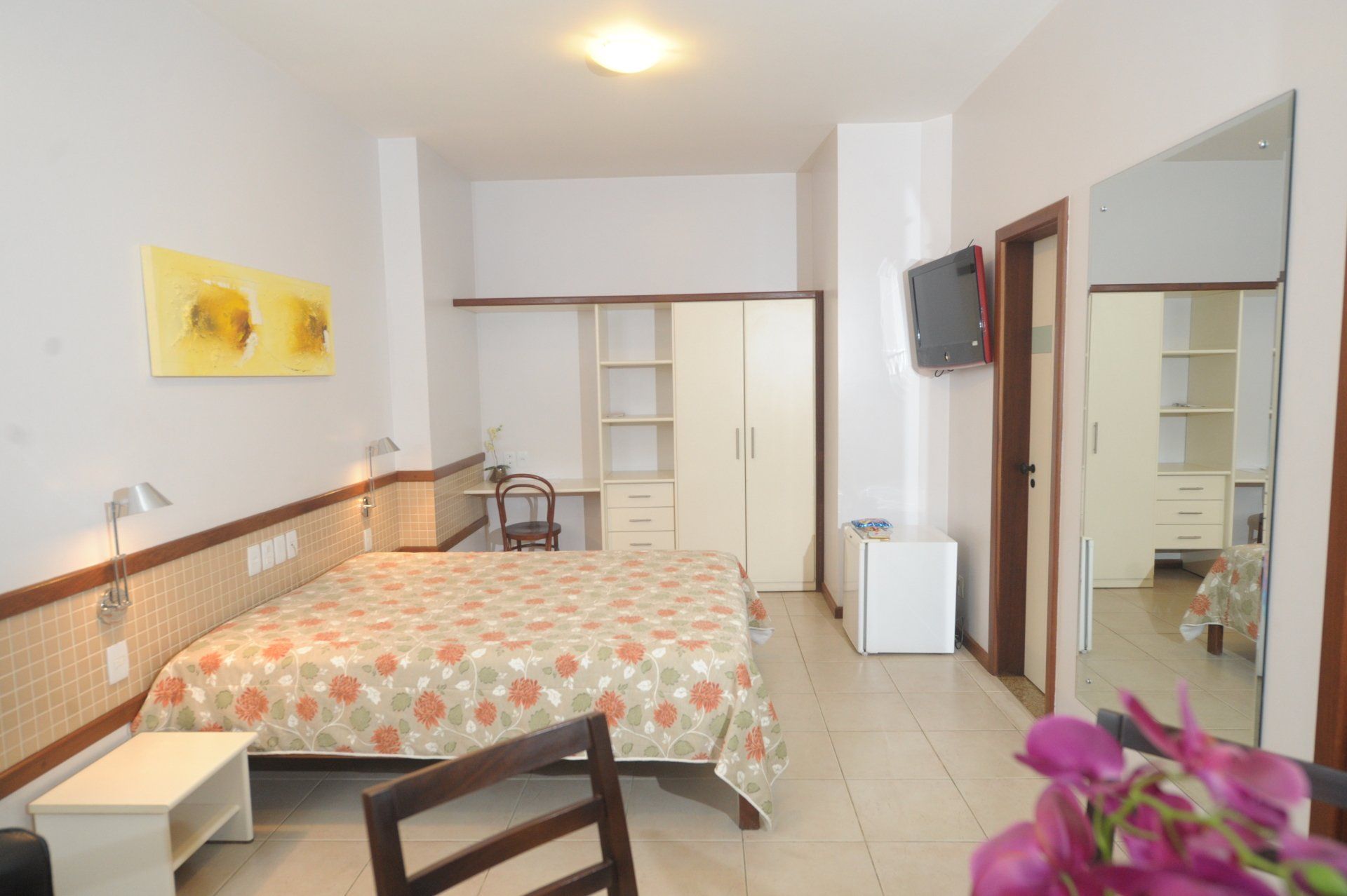 Um quarto do hotel Portal da Princesa com uma cama king size e uma cadeira