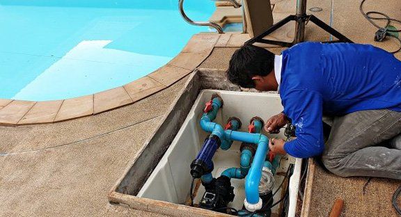 Man Cleaning Pool Pump — Staunton, VA — Valley Pool & Spa Man Cleaning Pool Pump — Staunton, VA — Valley Pool & Spa