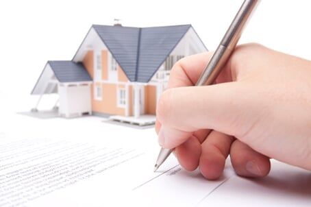 Miniature House — Bozeman, MT — Bozeman Independent Agency, Inc. A person signing a contract for homeowners insurance in Bozeman, MT