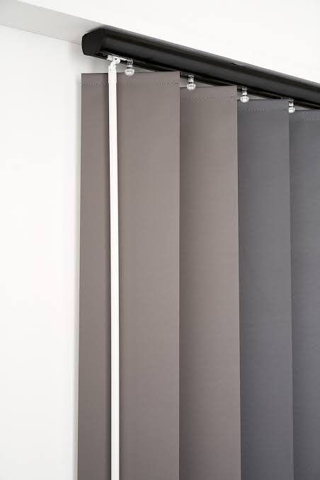 Vertical gray blinds mounted on a black track against a white wall.
