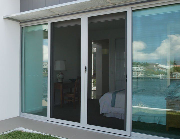 Sliding glass doors with a screen, overlooking a water view.
