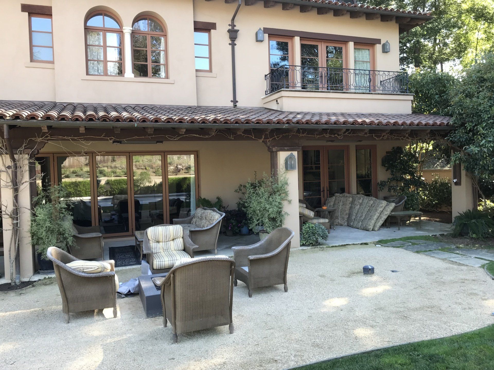 Patio of a house with outdoor furniture and a fire pit.