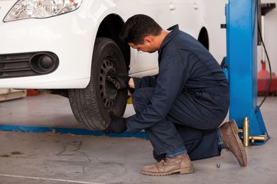 auto mechanic rotating a car's tires