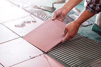 Worker Installing Tiles — Home Improvement in Hampton, VA Worker Installing Tiles — Home Improvement in Hampton, VA