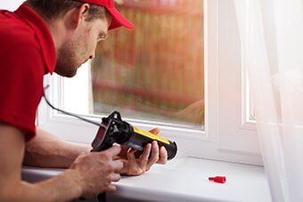 Worker Repairing White Window — Office Improvement in Hampton, VA Worker Repairing White Window — Office Improvement in Hampton, VA