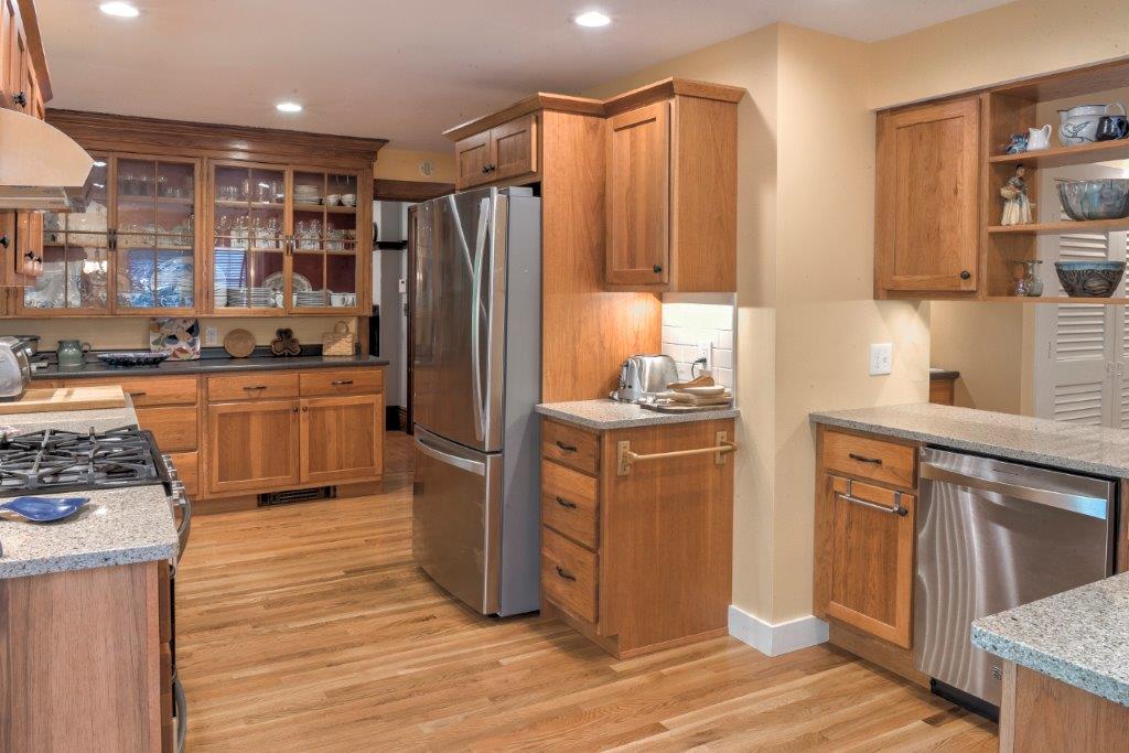 Modern kitchen with wood cabinets, stainless steel appliances, and hardwood floors