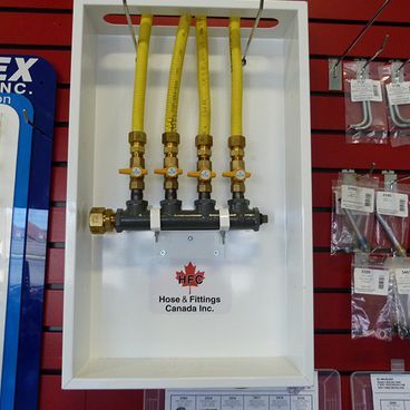 White box displaying yellow gas lines, brass fittings, and shut-off valves for demonstration.