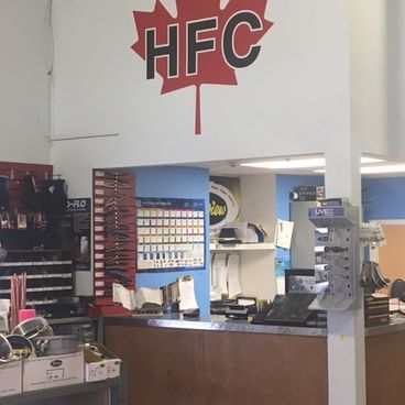 Interior of a store, with counter and shelves displaying products. HFC logo above.