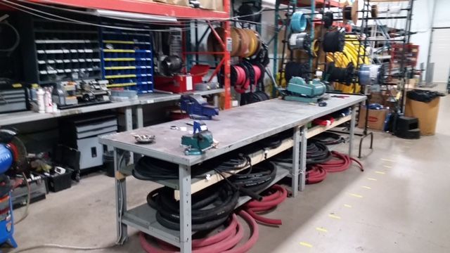 Workshop with workbench, tools, and storage shelves.