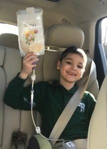 Young person holding the Bolee Bag while tube feeding in a vehicle