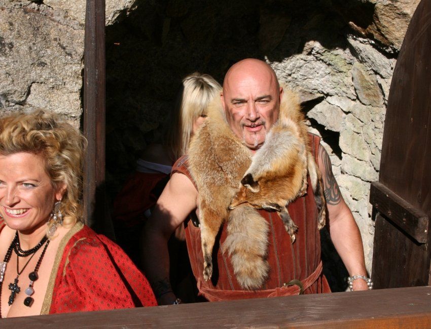 Ein Mann im Pelzmantel steht neben einer Frau