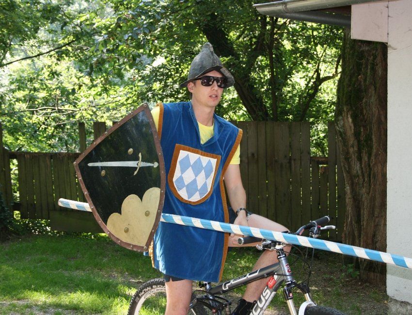 Ein Mann im Ritterkostüm fährt Fahrrad
