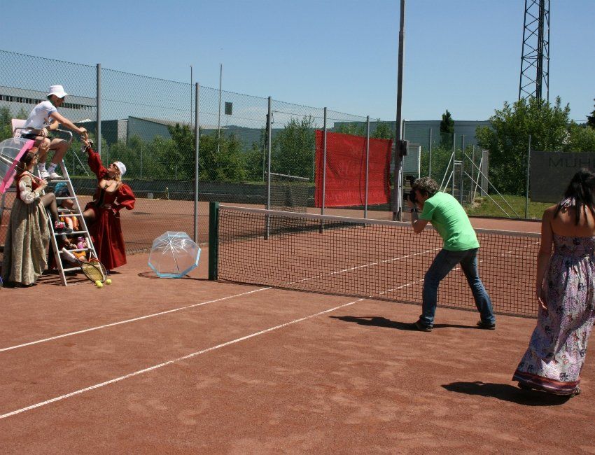 Eine Gruppe von Menschen spielt Tennis auf einem Tennisplatz
