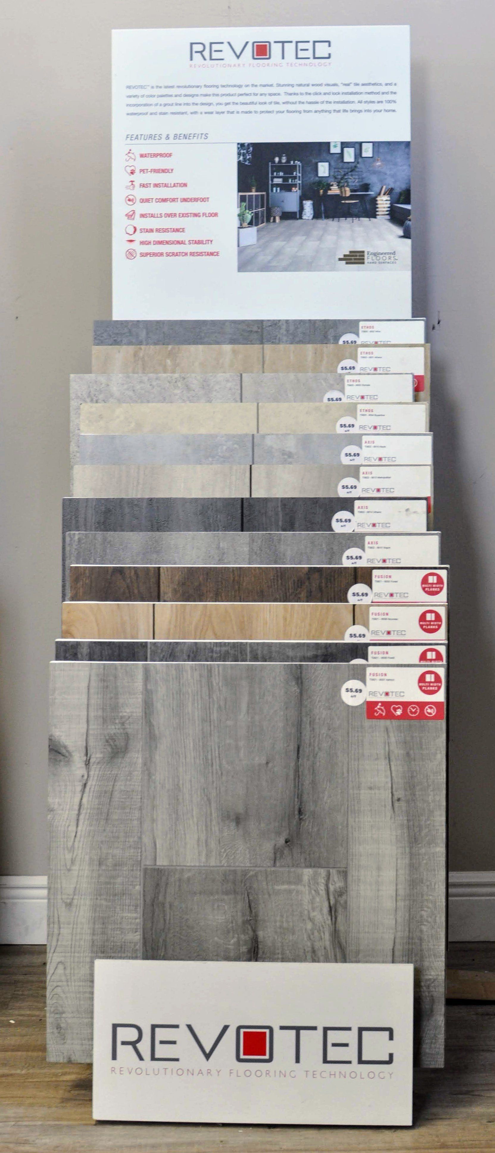 Display of Revtec wood flooring samples on a stand with various gray, beige, and brown planks