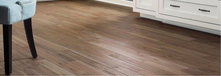 Wood-look floor beside a light blue chair and white cabinet in a bright room