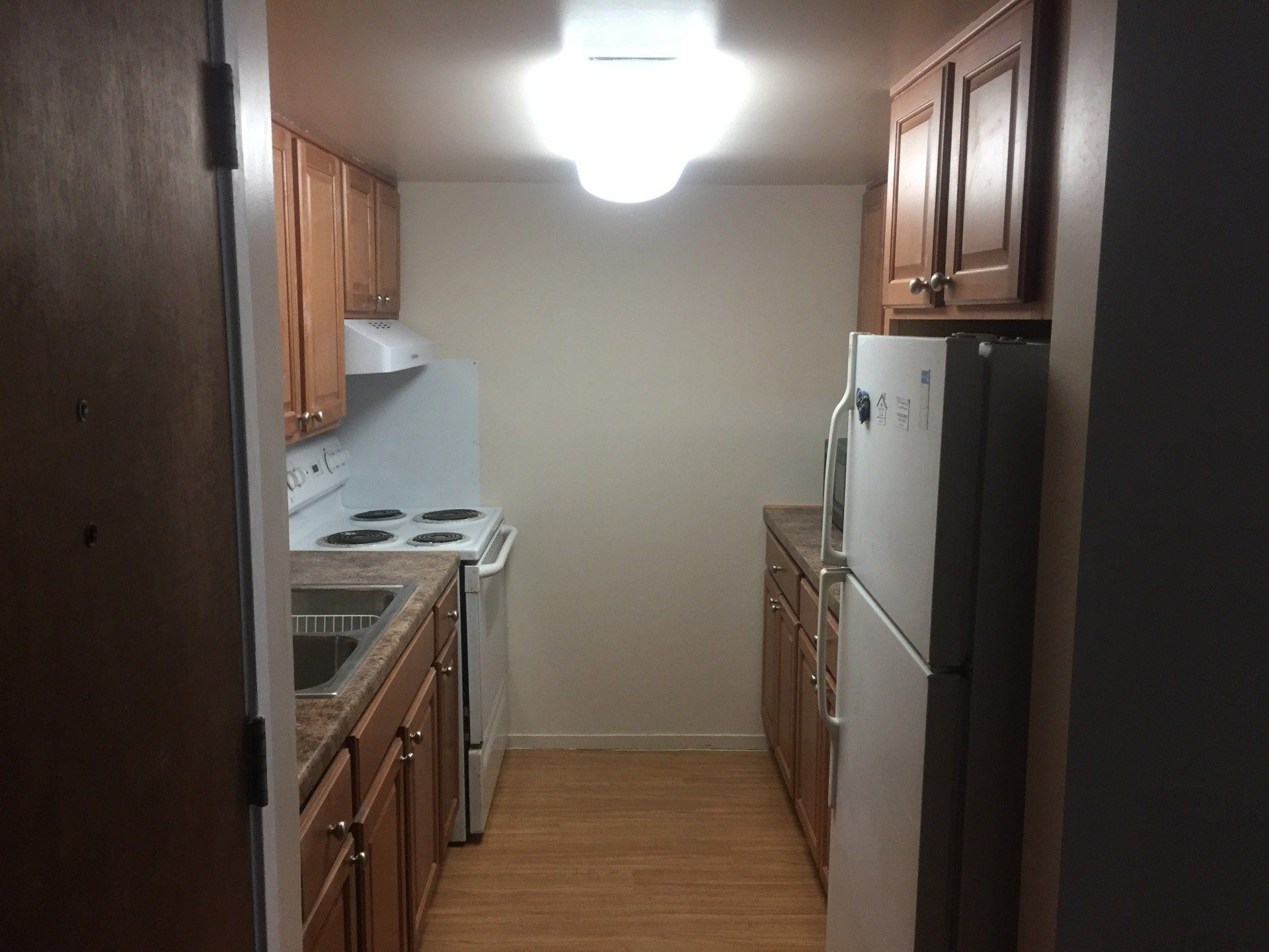 A kitchen with a refrigerator stove and sink