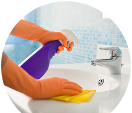 a person wearing orange gloves is cleaning a bathroom sink