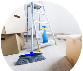 a room with boxes , a ladder , a broom and a spray bottle .