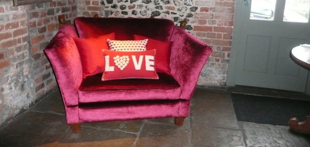 wing sided chair in deep pink with cushion carrying appliqued word Love