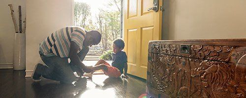 father putting on a shoe to his kid