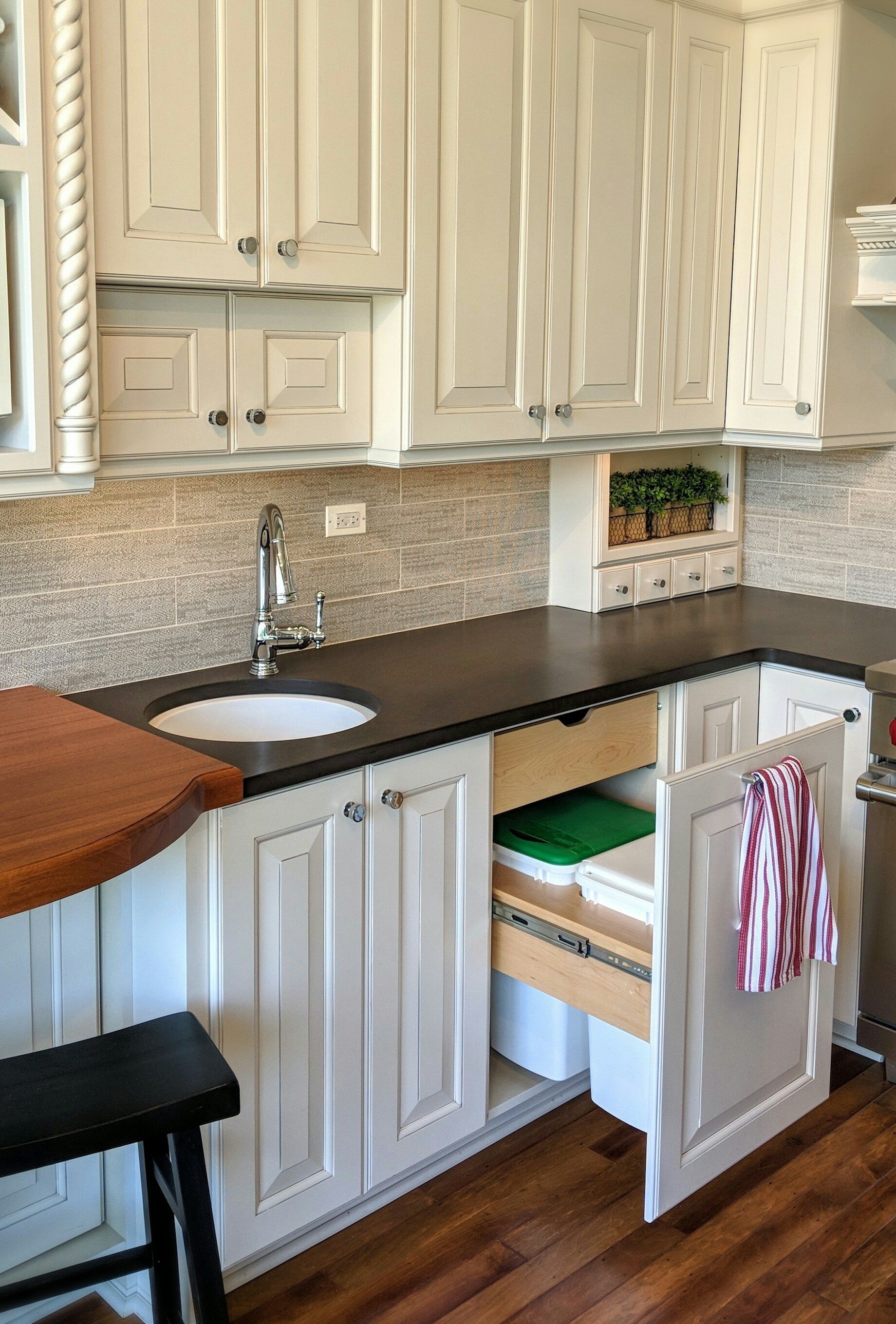 Double trash bin near kitchen prep sink for garbage and recycling.