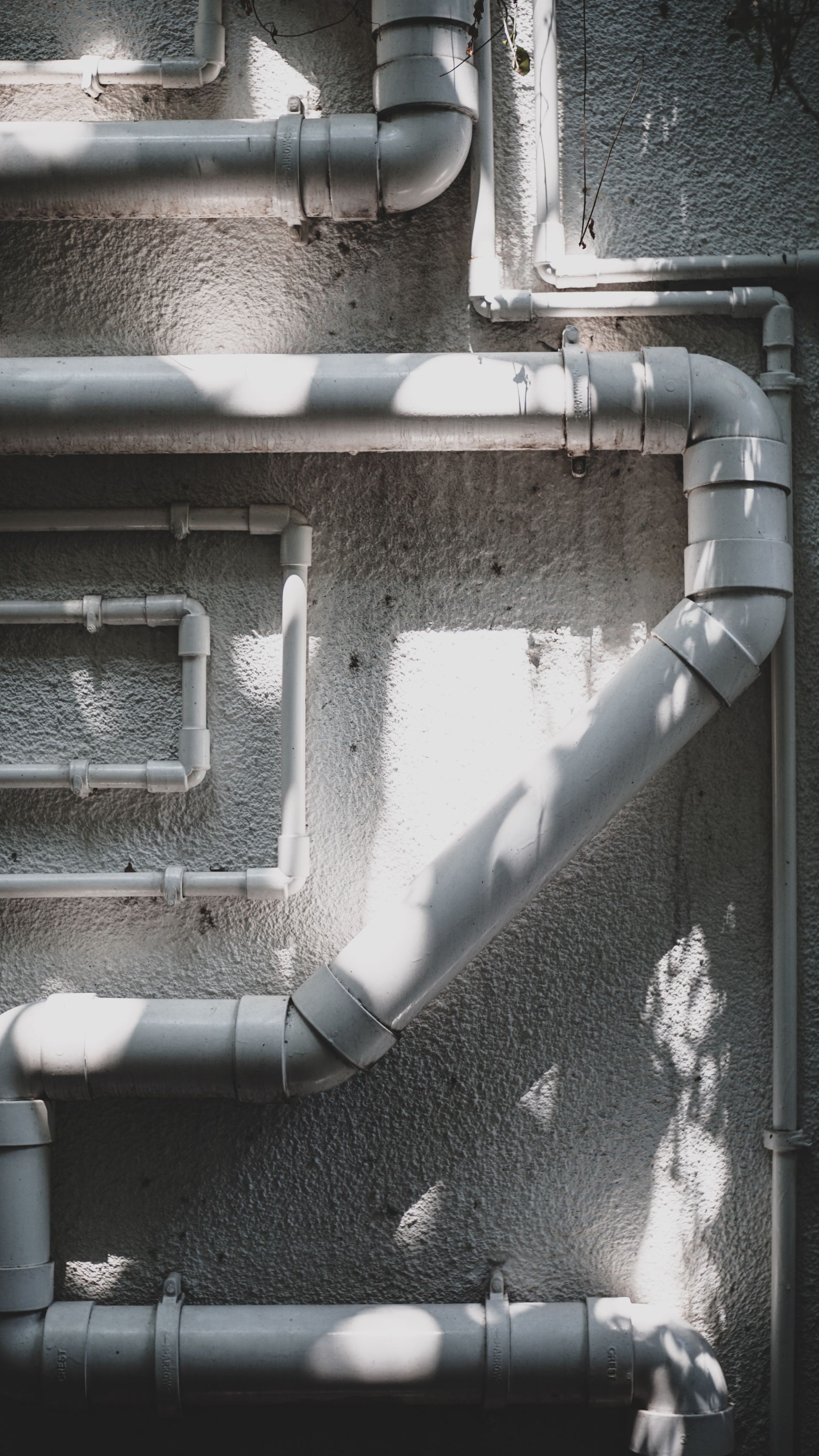 A bunch of pipes are connected to each other on a wall.
