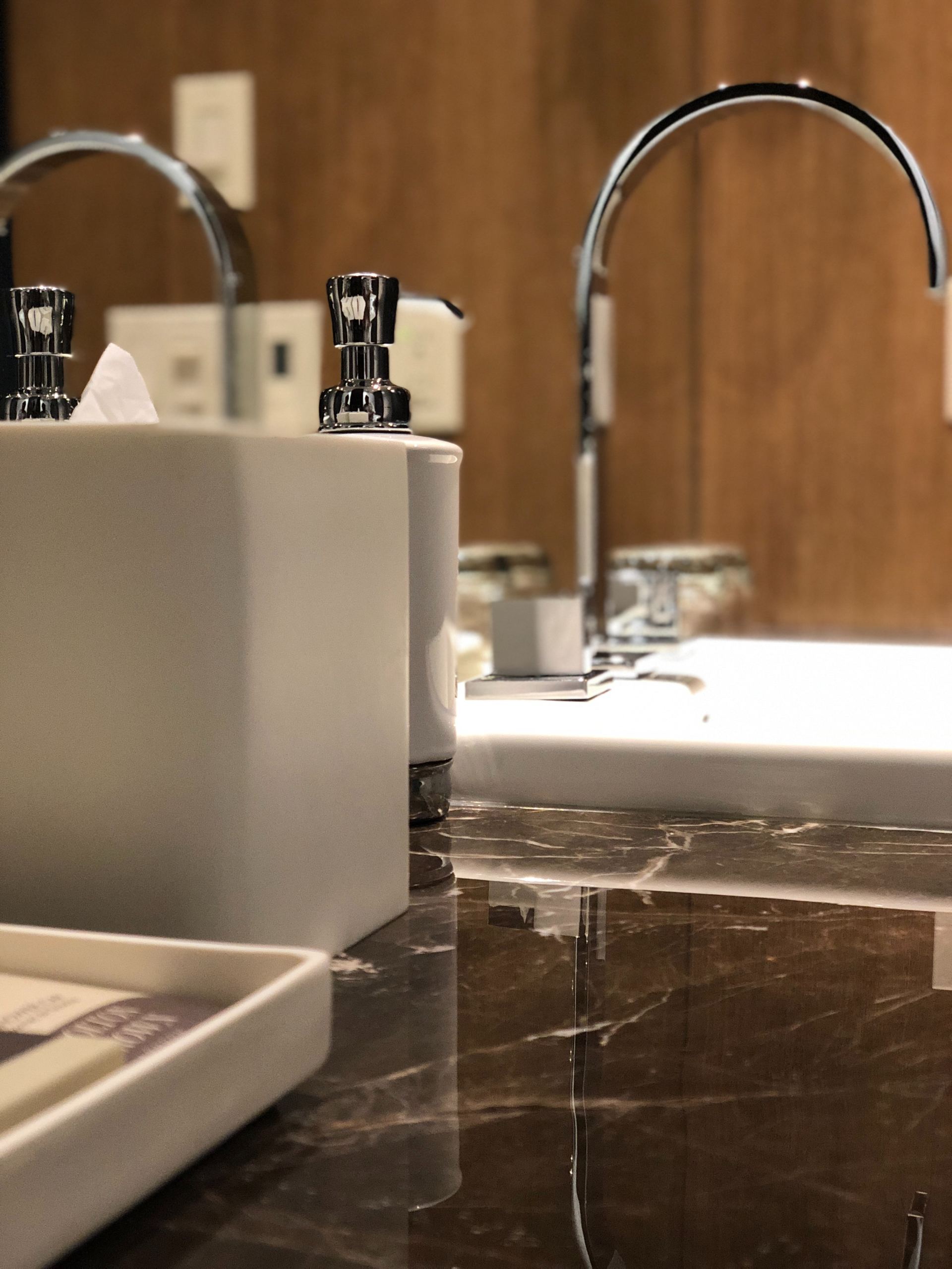 A bathroom sink with two faucets and a mirror