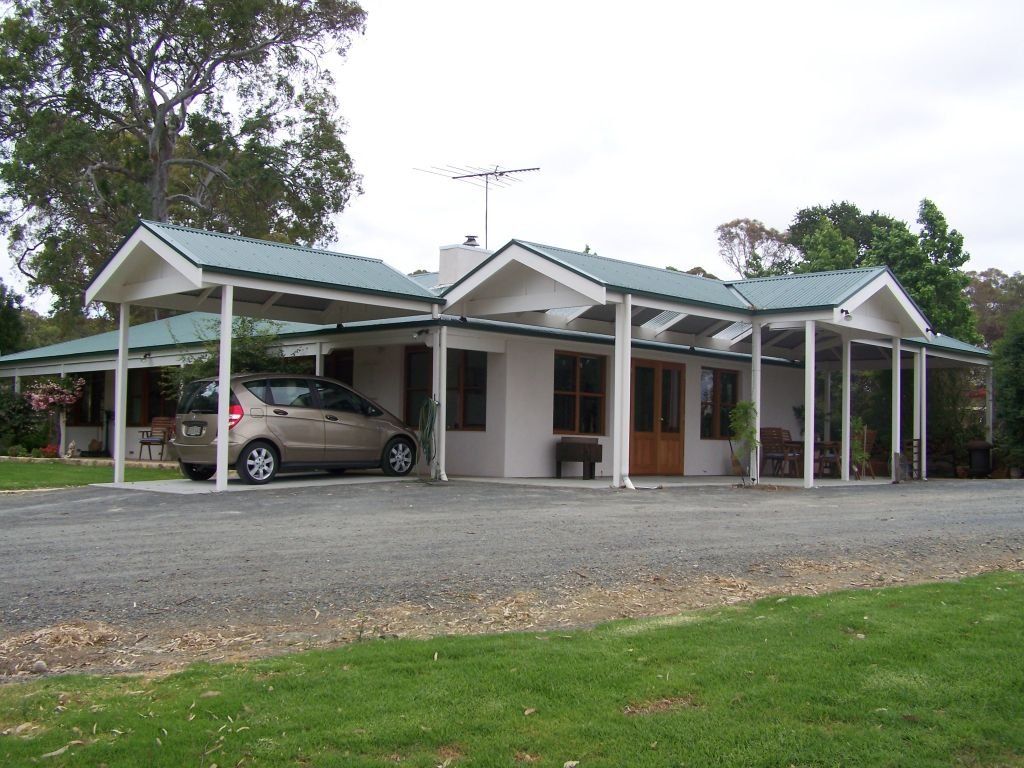 Single-storey home with pitched metal roofs, covered verandah and attached carport.