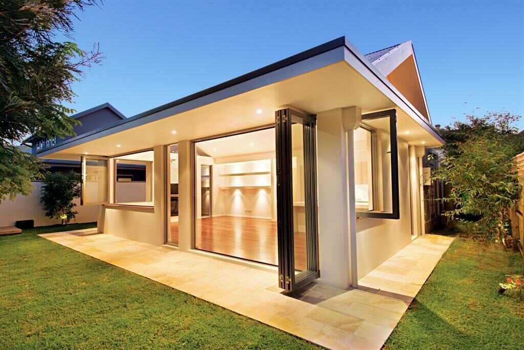 Modern home extension with large folding glass doors opening onto a landscaped backyard.