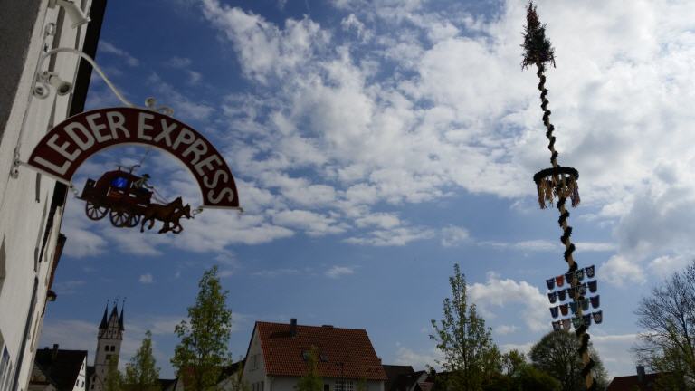 Ein Schild für Leder Express hängt an der Seite eines Gebäudes