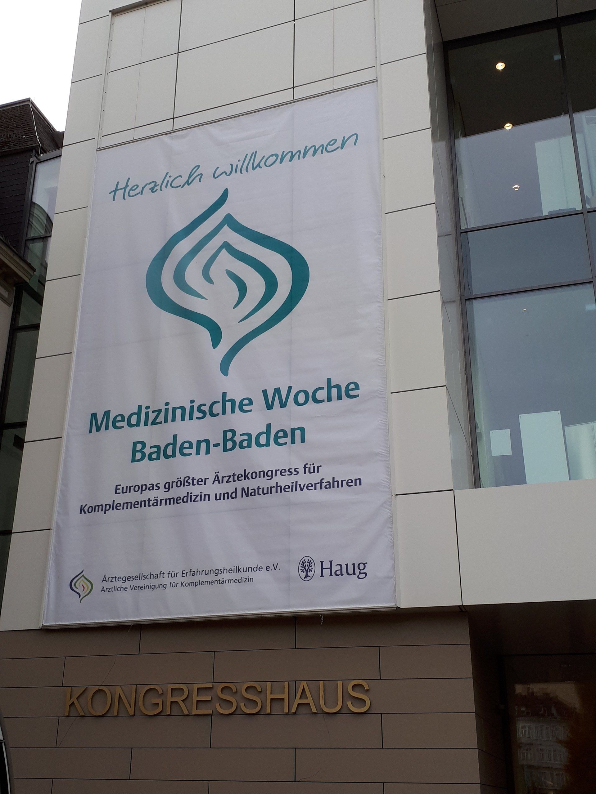 A large banner on the side of a building says medizinische woche baden-baden