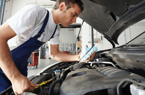 Mechanic checking oil level under car bonnet