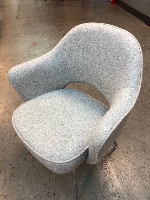 A grey chair is sitting on a concrete floor.