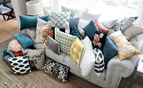 A couch covered in lots of colorful pillows in a living room.