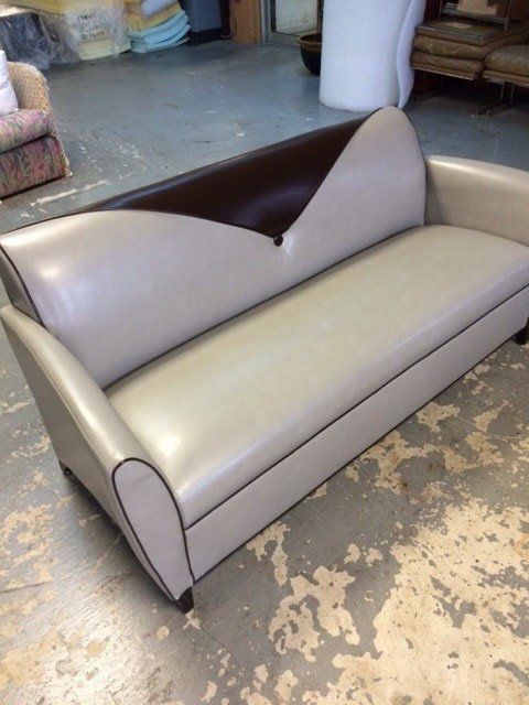 A couch is sitting on a concrete floor in a room.