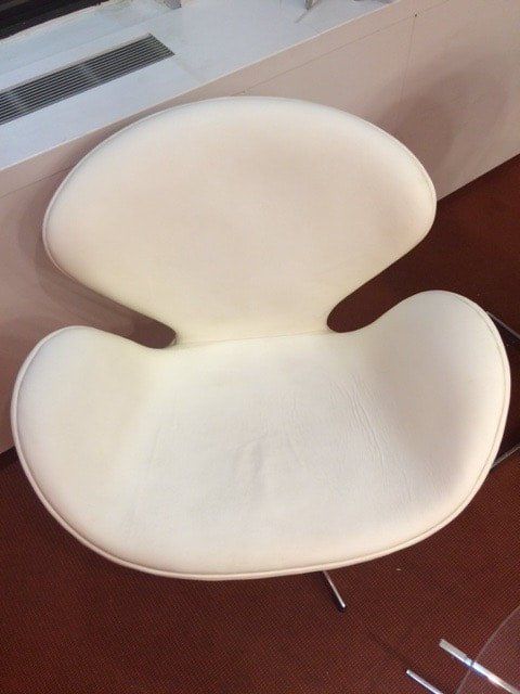 A white chair is sitting on a brown floor