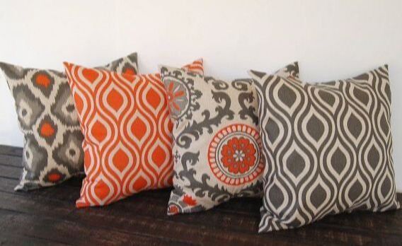 Four colorful pillows are sitting on a wooden table