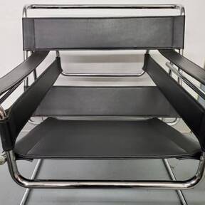 A black leather chair with a chrome frame is sitting on a table.